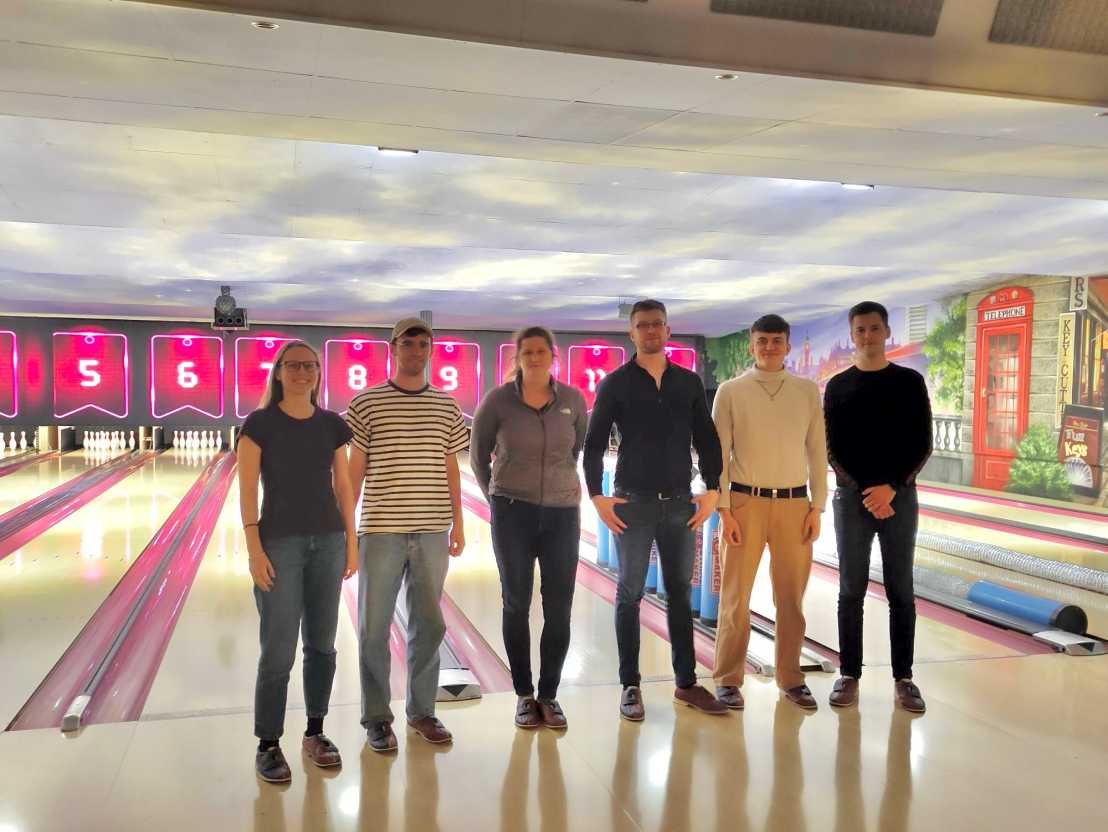 Frei Group standing in front of bowling alley